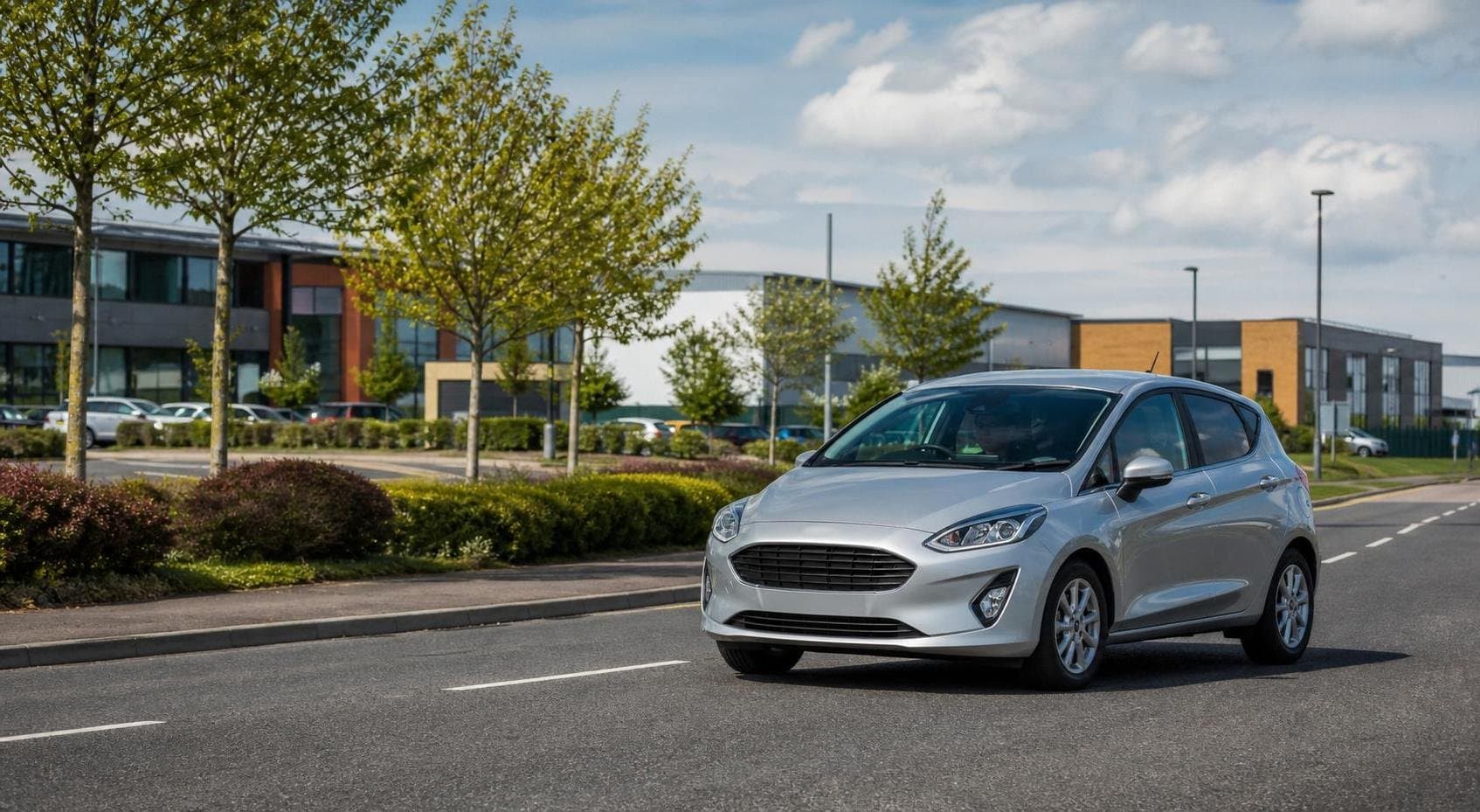 Compact hire car on a business-route approach near Durham in a realistic regional travel setting